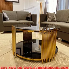 This elliptical center table features a striking design with a gold electroplated steel base and a black glass top. It is a substantial piece that adds a touch of glamour and serves as a focal point in a modern living room setting.