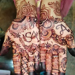 A close-up of a personalized design with the initials 'S' and 'A' beautifully incorporated into the intricate patterns on the palms.
