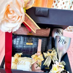 This personalized couple's hamper is perfect for a wedding or anniversary. It includes 'Mr & Mrs' glasses, matching passport covers and luggage tags, and personalized towels.