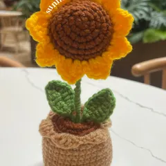 A single, cheerful sunflower to brighten your day. This handmade potted sunflower is perfect for adding a little sunshine to your desk or a small shelf.