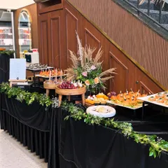 This elegant grazing table for the Looks Salon launch was designed with a black velvet drape and lush greenery. The spread included a variety of canapés, cheeses, and fruits to create a sophisticated welcome.