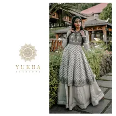 A model showcasing a layered Anarkali gown with block-printed details. The design combines a flowing printed skirt with a structured, embroidered bodice for a unique Indo-Western feel.
