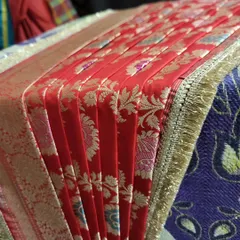 A detailed shot of the crisp pleats on the red bridal saree.