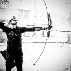 A moment of pure focus captured in black and white. This image highlights the mental stillness and concentration required to execute a perfect shot and hit the bullseye under pressure.