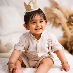 A joyful, candid shot of the birthday boy. The soft, neutral tones of the boho setup create a calm and beautiful atmosphere.