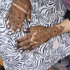 This design combines many different elements, from filled fingertips and detailed finger bands to a circular mandala and floral patterns extending to the wrist.