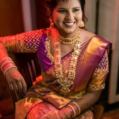 A radiant portrait of the bride-to-be, her smile lighting up the frame, showcasing her stunning purple and gold engagement saree.