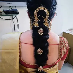 This is a classic leaf braid, also known as a fishtail braid, decorated with traditional gold accessories. It’s a popular choice for weddings and other grand functions.