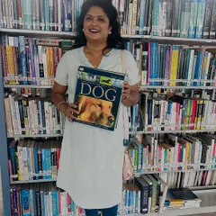 My passion for dogs goes beyond just caring for them. I'm always learning, here at a library with a comprehensive book on dogs to deepen my knowledge.