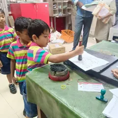 A student gets a hands-on experience stamping a document at the post office, learning how mail was traditionally processed.