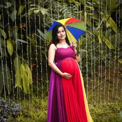Celebrate your pregnancy with a splash of color. This vibrant, multi-hued maternity gown is perfect for outdoor photoshoots and creates a joyful, memorable look. I help style the entire shoot, from the gown and makeup to finding the perfect location in Bengaluru.