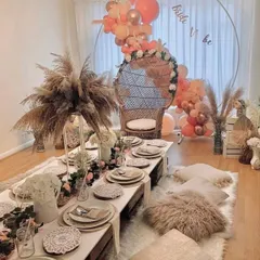 We love a boho bridal shower. For this event, we created a dreamy floor seating arrangement with low picnic tables, plush cushions, pampas grass, and a beautiful balloon arch for the bride-to-be's special peacock chair.