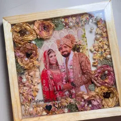 Your wedding memories, beautifully displayed. I preserved this couple's varmala and wedding photo in a classic wooden shadow box frame. The flowers are carefully arranged to create a stunning 3D effect, making it a perfect centerpiece for your wall.