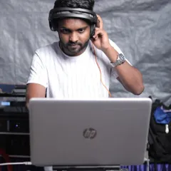 Listening closely to cue up the next track. Every transition is planned to maintain the party's momentum.
