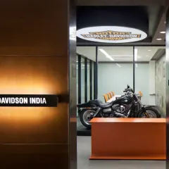 The entrance to the Harley-Davidson India office immediately immerses visitors in the brand's world. A signature motorcycle is displayed prominently in a glass-enclosed meeting room, making a bold statement about the company's passion and heritage.