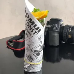 A creative and low-cost presentation idea. This drink is wrapped in newspaper print, giving it a rustic and unique look that stands out.