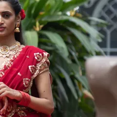 Our muse in a striking red ensemble, featuring a blouse with delicate zardosi work on the sleeves. A look that is both powerful and graceful.
