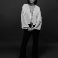 A full-length studio portrait in black and white. The simple, elegant styling and the soft, diffused light create a timeless and classic look.