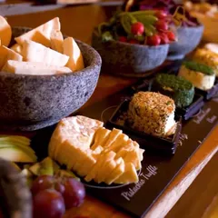 A close up of my Indian charcuterie board, featuring different types of paneer and vegetarian cheeses, served with fresh fruits and radishes.