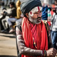 Not every shot is a direct portrait. Much of my work is about capturing people as they are, living their lives. This candid moment on the streets of Varanasi shows a sadhu amidst the energy of the festival.