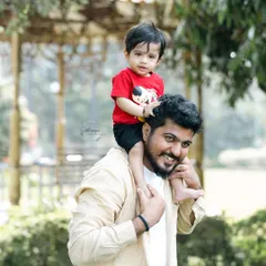 Another angle of a father giving his son a shoulder ride. The focus is on the child's happy expression and the strong bond between them.