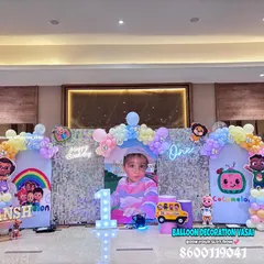 An elaborate Cocomelon theme for a grand first birthday celebration. This setup features multiple backdrops, all the character cutouts, and pastel balloon arrangements.