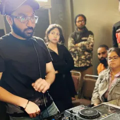 An over-the-shoulder view of a hands-on training session. Students gather around the console to see the techniques up close and ask questions in real-time.
