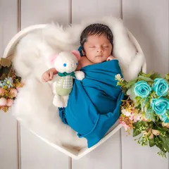 There is nothing more pure than a sleeping newborn. For this portrait, I used a heart-shaped basket and soft white fur to gently cradle the baby, creating a timeless image of peace and new love.