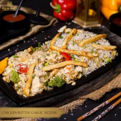 Our Creamy Chicken Butter Garlic Sizzler is a symphony of flavors. Tender chicken in a rich butter garlic sauce is served over rice and vegetables on a sizzling platter.
