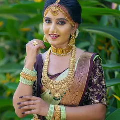 A classic bridal pose showcasing the rich temple jewellery and the neat fall of a light green Kanjivaram silk saree. The drape is set to highlight the ornate kamarbandh and blouse embroidery.
