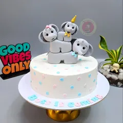 An adorable elephant-themed baby shower cake with the message "Boss is Coming". The stacked elephants are completely handmade.