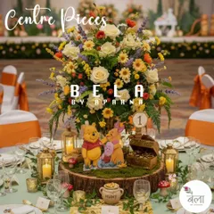A close-up of a table centerpiece for the Pooh theme. It combines a vibrant floral arrangement with a tree-stump base, a miniature treasure chest, and adorable cutouts of Pooh and Piglet, ensuring every table is part of the story.