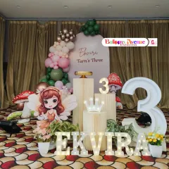 A full view of Ekvira's fairy-themed third birthday party. The decoration features a large fairy cutout, light-up name and number props, and a soft-colored balloon arch.
