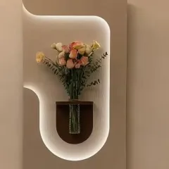 A creative wall detail featuring a custom-shaped niche with integrated backlighting. This design turns a simple wall into a display area, perfectly highlighting a flower vase or other decorative objects.