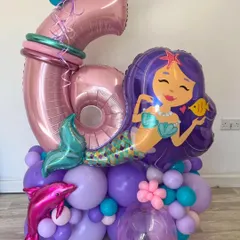 A mermaid-themed balloon bouquet for a 6th birthday, complete with a large mermaid foil balloon and a dolphin accent.