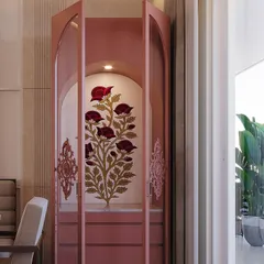 A closer look at the pink pooja unit with its doors open, revealing the built-in lighting that highlights the beautiful floral artwork inside. This piece is a testament to custom craftsmanship.
