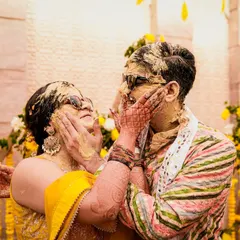 A playful Haldi moment between the bride and groom. These are the fun, messy, and memorable interactions that make for great candid wedding photography.