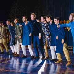 The groom and his groomsmen, a mix of friends from different backgrounds, all dressed in traditional Indian wear for their group performance. I love seeing this kind of energy and camaraderie on stage.
