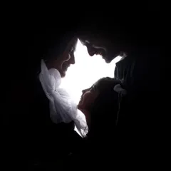 A beautiful and intimate family silhouette. The light creates a heart shape around their faces as they share a loving moment with the big-sister-to-be.