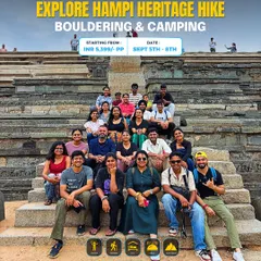 Our group posing on the steps of a historic structure in Hampi. This trip combines heritage exploration with adventure activities like bouldering and camping.