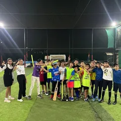 A group of happy kids and parents posing for a photo after an amazing cricket-themed birthday party.