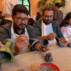 Two friends concentrating on painting their hand-built pots. It's a great way to spend quality time together, chatting and creating.