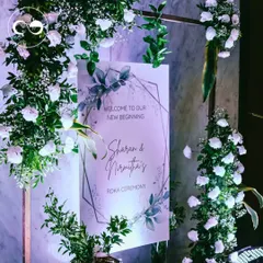 The custom welcome sign for a Roka ceremony, framed by an arch of fresh white flowers and greenery. This was the first beautiful detail guests saw as they arrived to celebrate the couple's new beginning.
