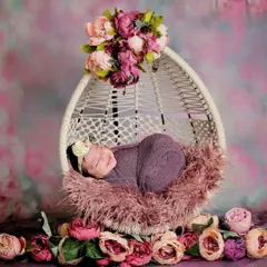 A sweet sleeping baby in a floral-themed setup. The purple wrap and surrounding peonies create a rich, colorful, and peaceful image.