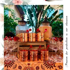 A beautifully themed bar setup featuring custom stirrers and elegant copper mugs, all tailored to the event's aesthetic.