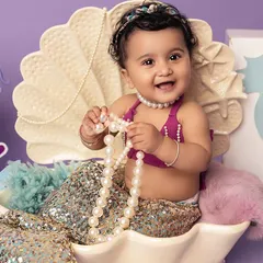 Pearls and giggles from the sweetest little mermaid. The details in this under-the-sea setup, from the sparkling tail to the pearl necklace, create a truly magical ocean scene.