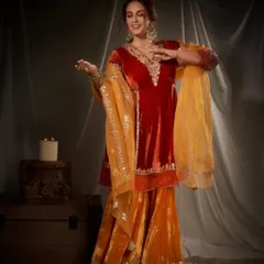 A joyful, candid moment that shows how comfortable and vibrant this festive outfit is. The combination of red and orange velvet is both traditional and eye-catching.