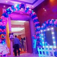 An entrance arch made of blue, pink, and chrome balloons for a Mickey and Minnie themed party. The arch frames the doorway, creating an exciting entry for kids and guests.