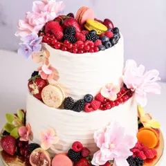 The beauty I crafted for Alia Bhatt. This two-tiered cake features layers of moist vanilla cake and 54% Belgian dark chocolate ganache, finished with vanilla buttercream, fresh berries, and macarons.