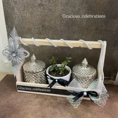 A perfect hamper for a silver jubilee celebration. This wooden tray is decorated in a silver and black theme and includes two silver crystal jars and a central planter. It's fully customizable and under ₹1000.